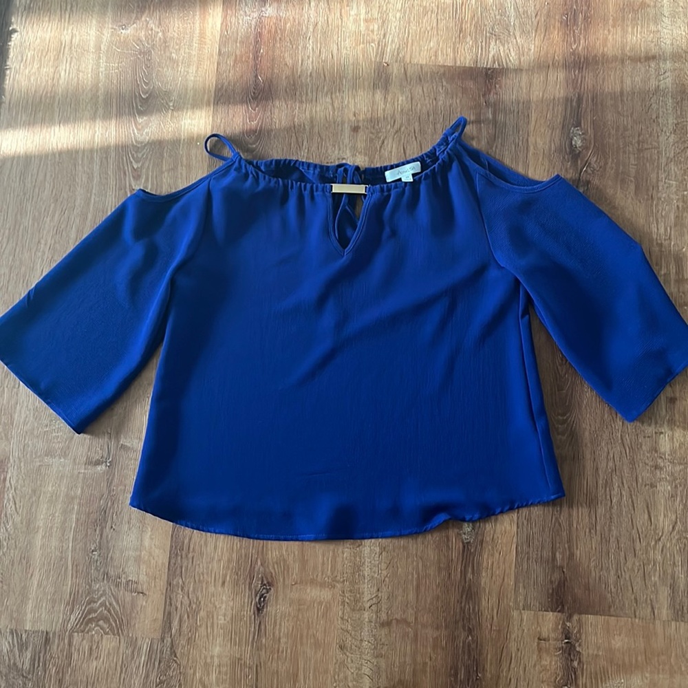 Loose fitted, cut outs at the shoulders, gold detail at the top